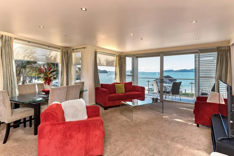 Un salon lumineux s'ouvre sur une vue mer par de grandes baies vitrées.