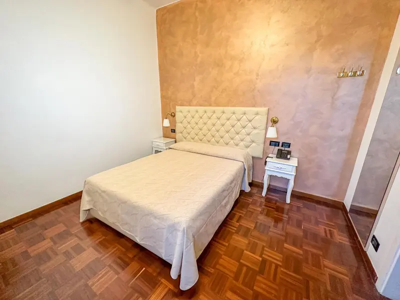 Une chambre avec un grand lit recouvert d'une courtepointe et des tables de chevet.