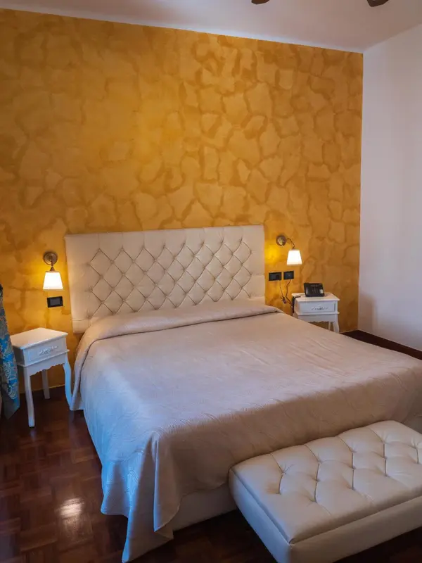 Une chambre lumineuse avec un grand lit recouvert d'une courtepointe matelassée.