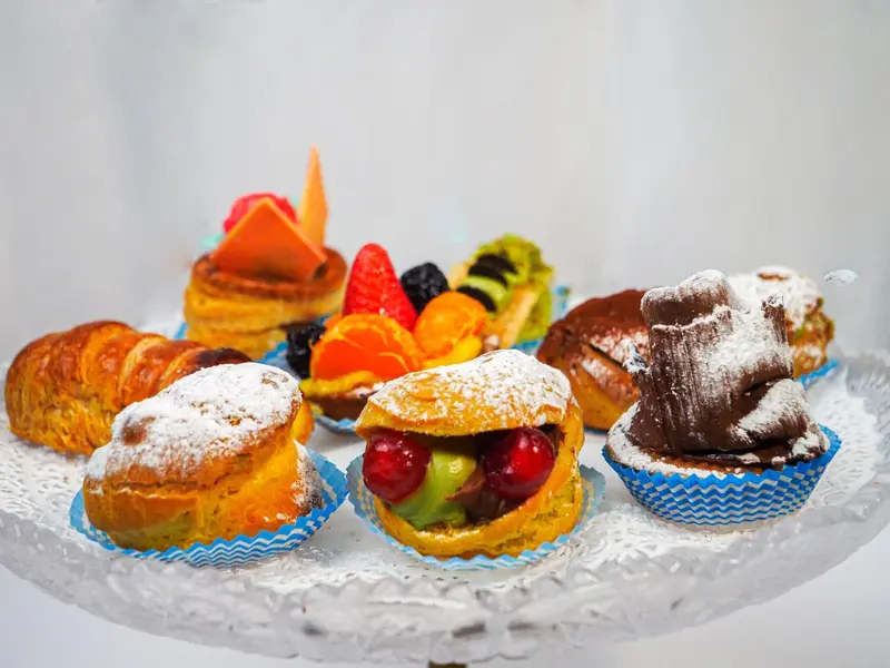 Assortiment de pâtisseries colorées présentées sur un présentoir.