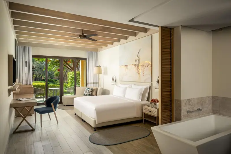 Une chambre lumineuse avec un grand lit et un espace détente.