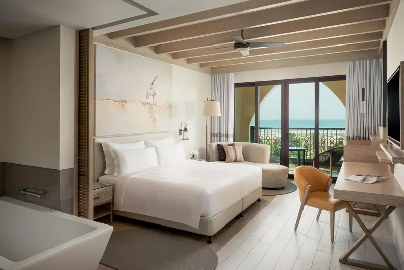Une chambre lumineuse avec un grand lit et un accès à une terrasse.