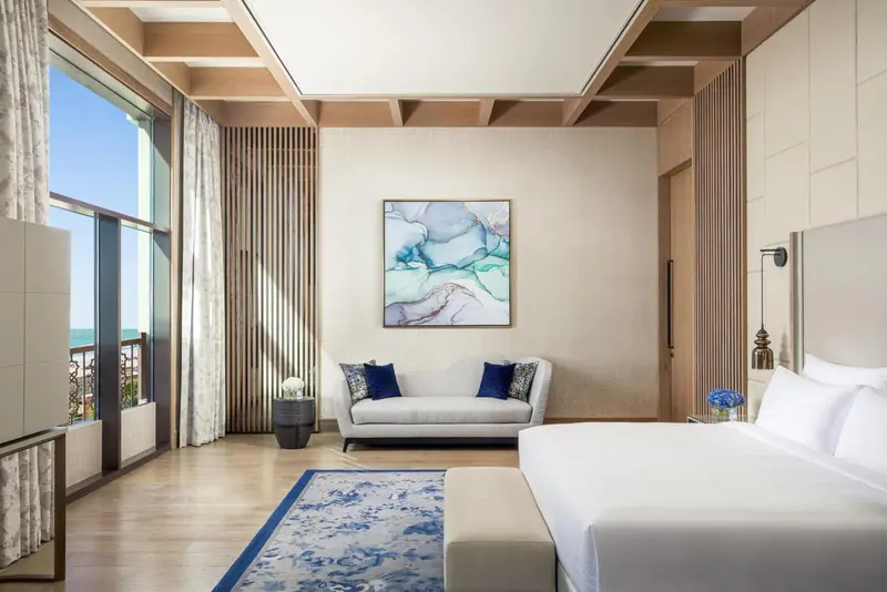 Une chambre lumineuse avec un grand lit et un espace détente.