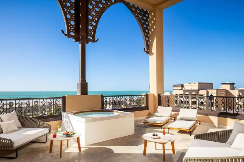 Terrasse aménagée avec salon et jacuzzi donnant sur la mer.