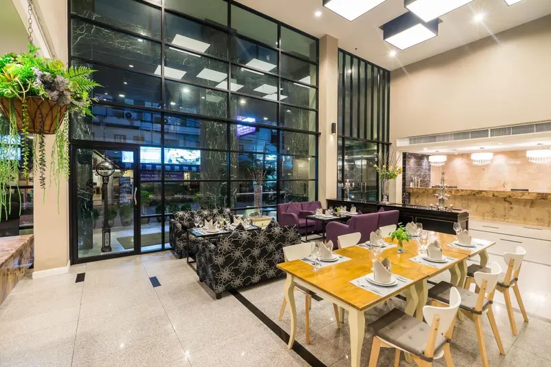 Une salle lumineuse avec des tables dressées et des canapés confortables.