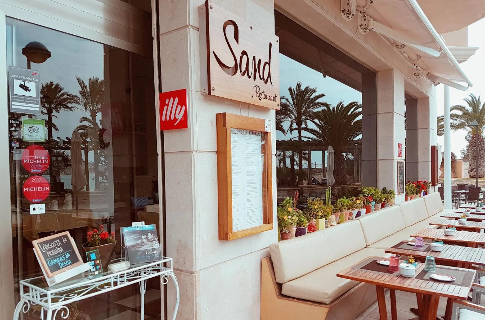 Façade d'un restaurant avec une terrasse ombragée et des tables en extérieur.