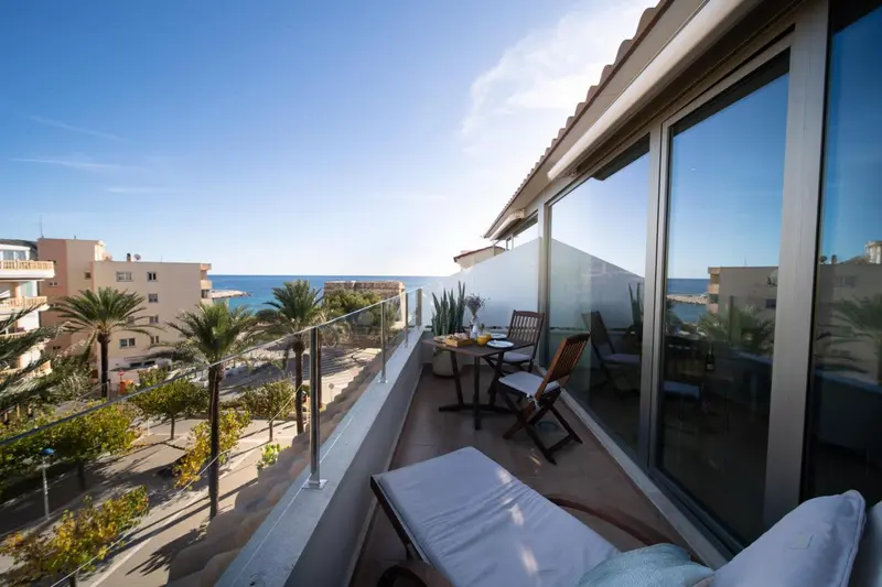 Une terrasse ensoleillée offre une vue sur la mer et la végétation environnante.