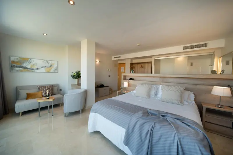 Une chambre lumineuse avec un canapé et un lit king-size.