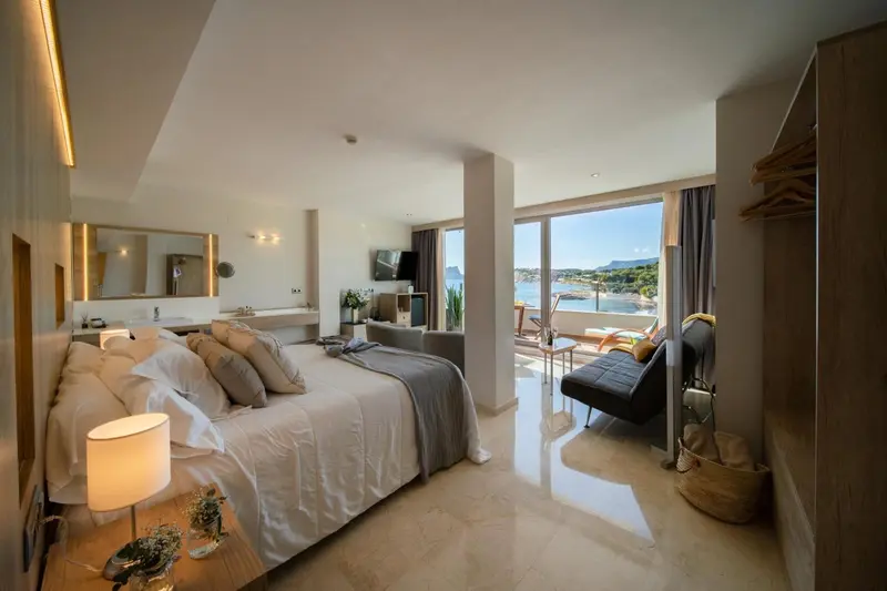 Une chambre lumineuse avec un grand lit et une vue sur la mer.