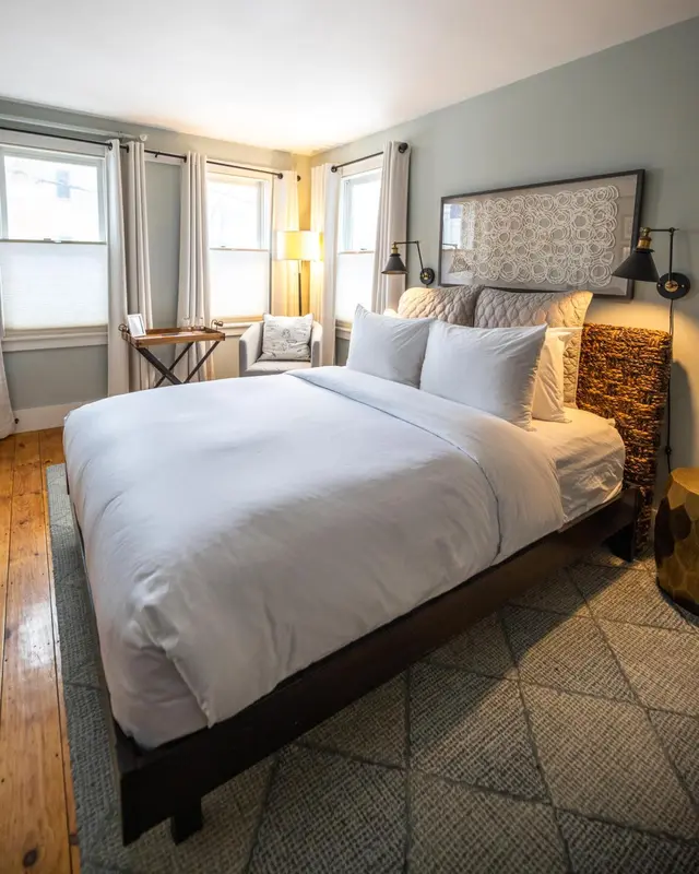 Une chambre lumineuse avec un grand lit recouvert de linge blanc.