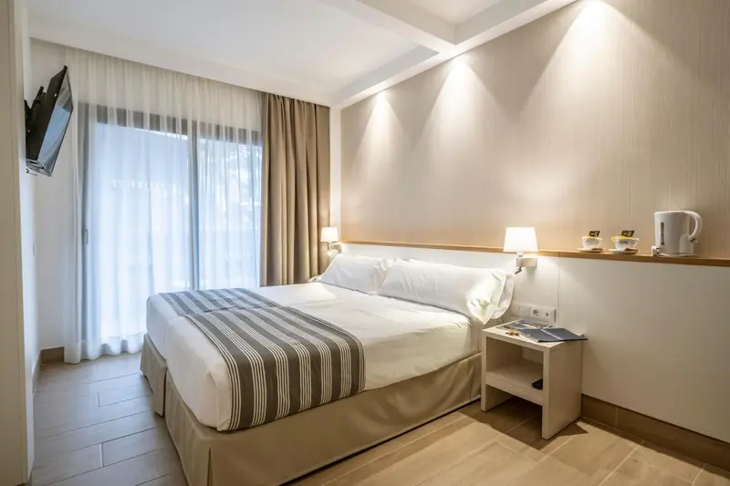 Une chambre lumineuse avec un grand lit et des tables de chevet.
