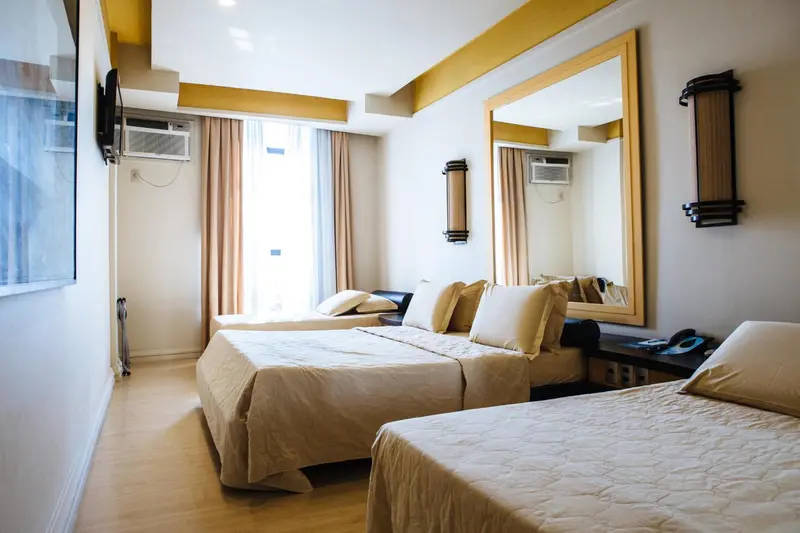 Une chambre d'hôtel lumineuse avec un grand lit et un miroir.