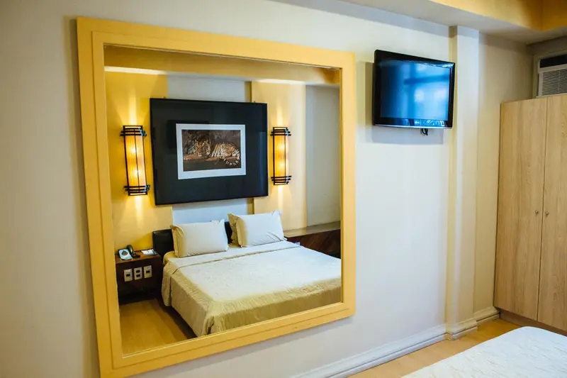 Une chambre d'hôtel avec un grand miroir au-dessus du lit.