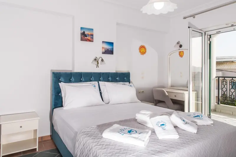 Une chambre lumineuse avec un grand lit et un accès à un balcon.