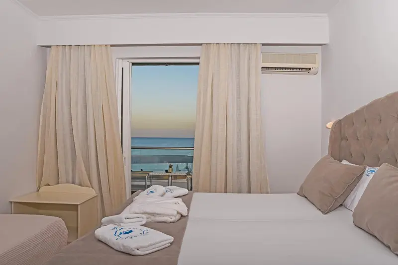 Une chambre lumineuse avec un grand lit donnant sur la mer.