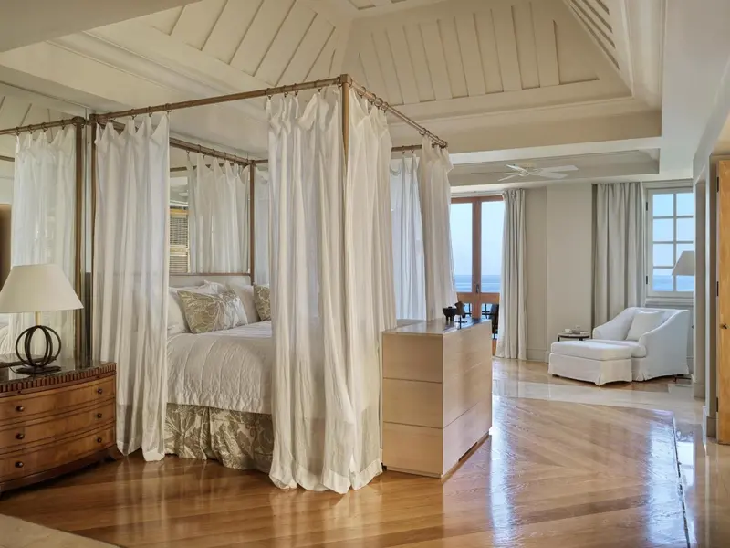 Une chambre spacieuse avec un lit à baldaquin et vue sur la mer.