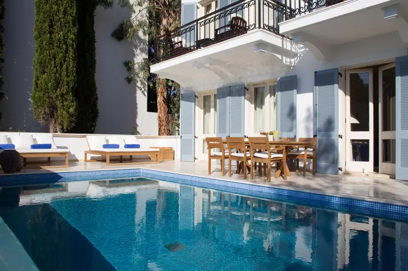 Terrasse avec mobilier de jardin et piscine ensoleillée.