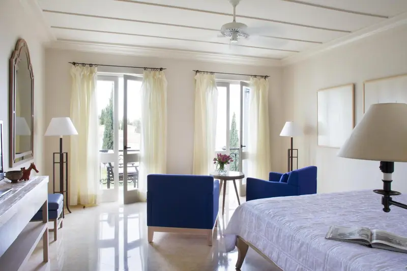 Une chambre lumineuse avec un lit et un coin salon.