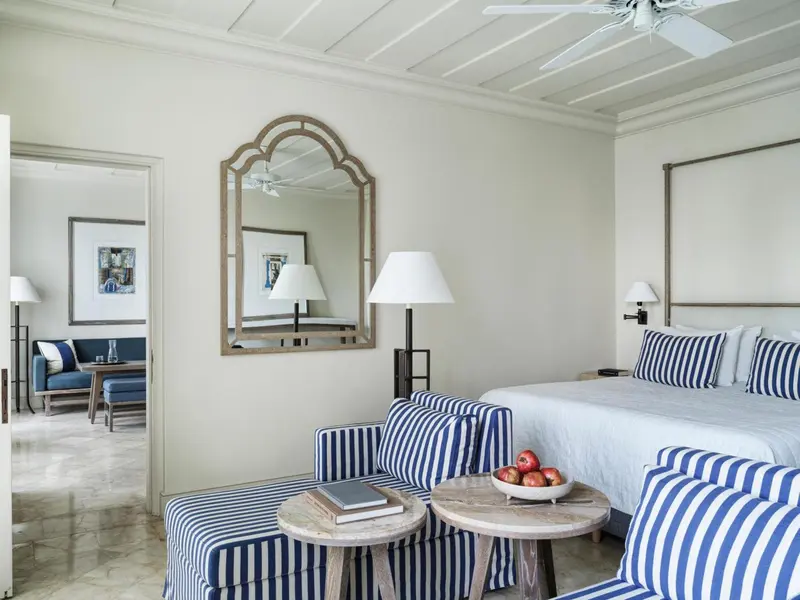 Une chambre lumineuse avec un grand lit et un coin salon.