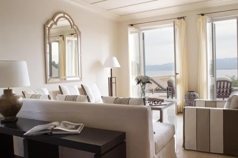 Espace de détente lumineux avec canapés et vue sur la mer.