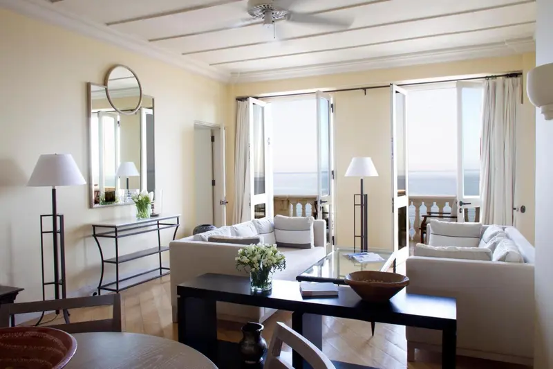 Un salon lumineux s'ouvre sur une terrasse avec vue sur la mer.