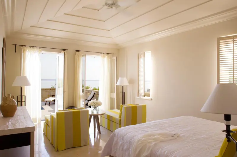 Une chambre lumineuse avec un coin salon et vue sur la mer.