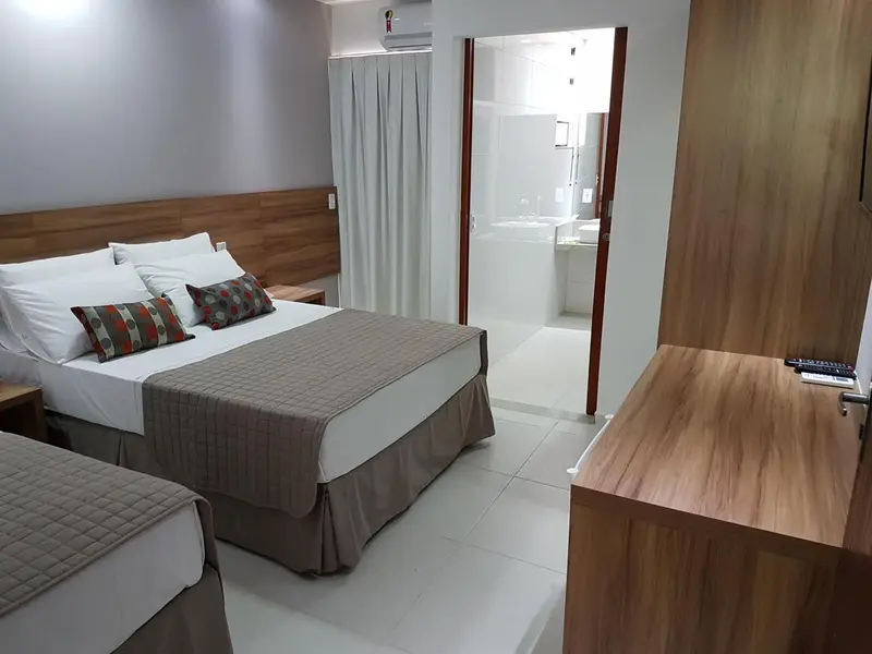 Une chambre d'hôtel lumineuse avec un grand lit et un accès à une salle de bain.