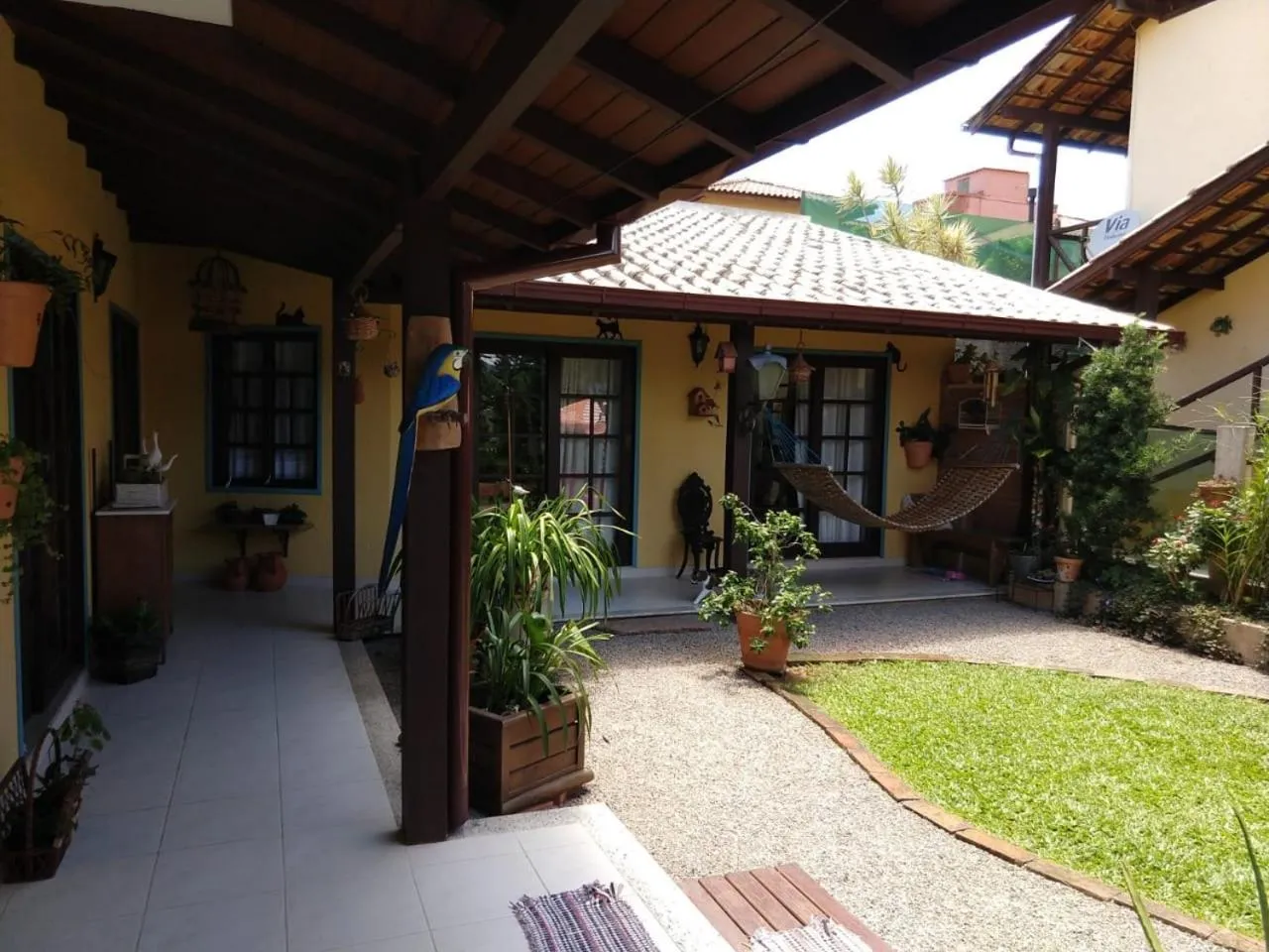 Terrasse ombragée avec des plantes et un hamac dans une cour intérieure.