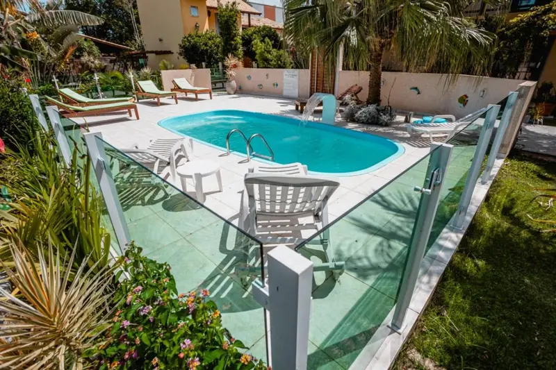 Transats blancs disposés autour d'une piscine rectangulaire ensoleillée.