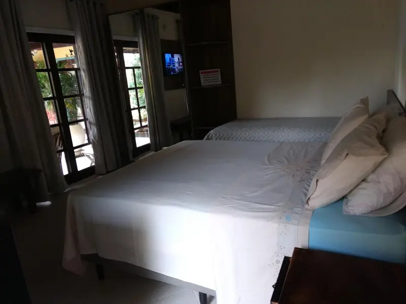 Une chambre lumineuse avec un lit recouvert de draps blancs.