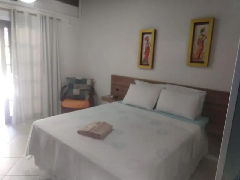 Une chambre lumineuse avec un grand lit recouvert d'une courtepointe blanche.