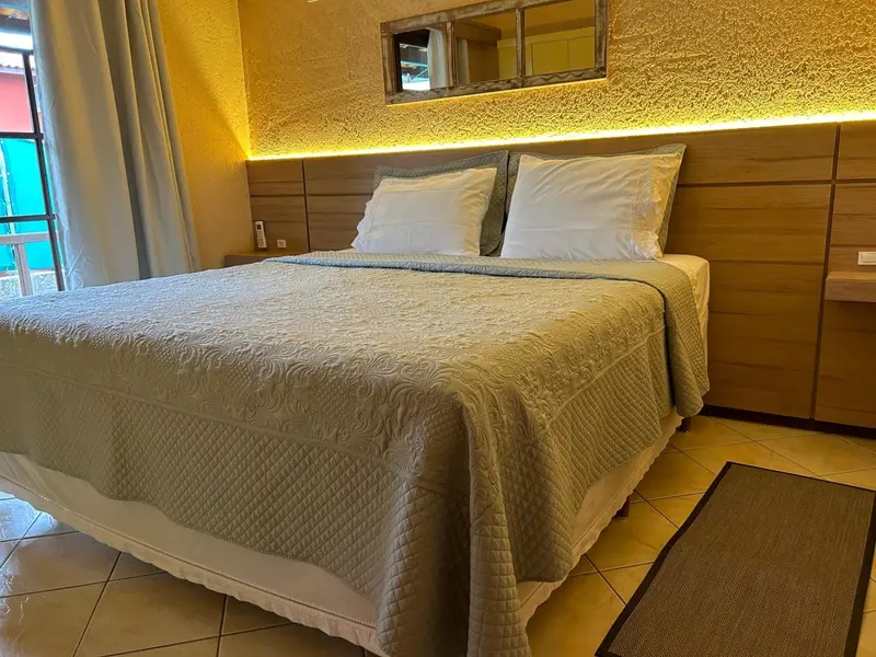 Lit double avec couvre-lit texturé dans une chambre lumineuse.