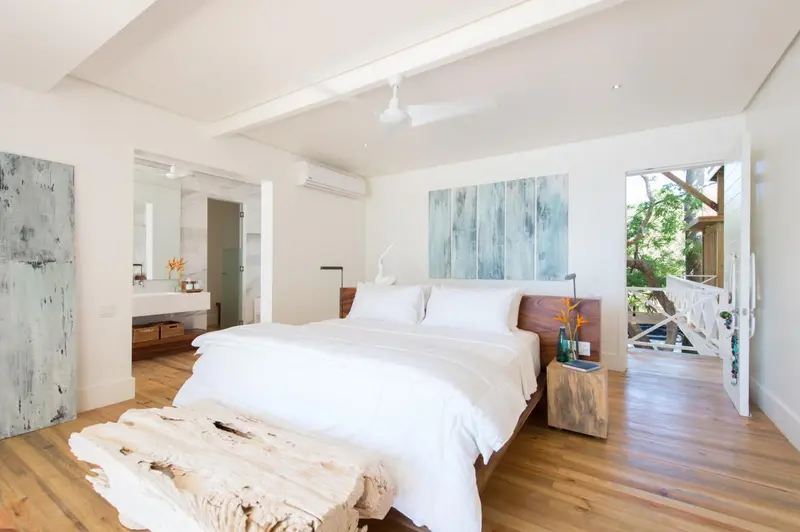 Une chambre lumineuse avec un grand lit recouvert de draps blancs.