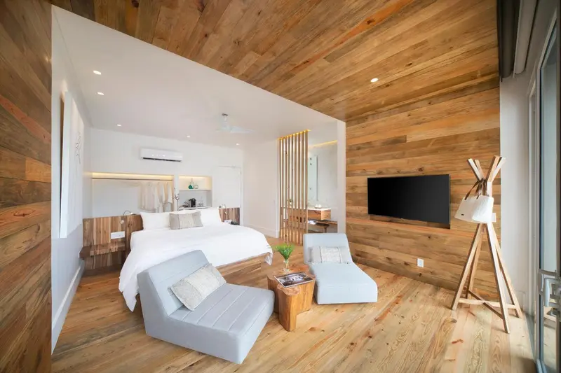 Une chambre lumineuse avec un lit king-size et un coin salon.