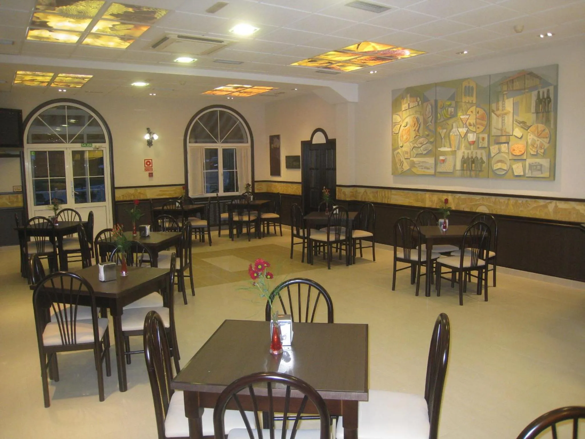 Une salle lumineuse avec des tables et des chaises disposées pour les repas.