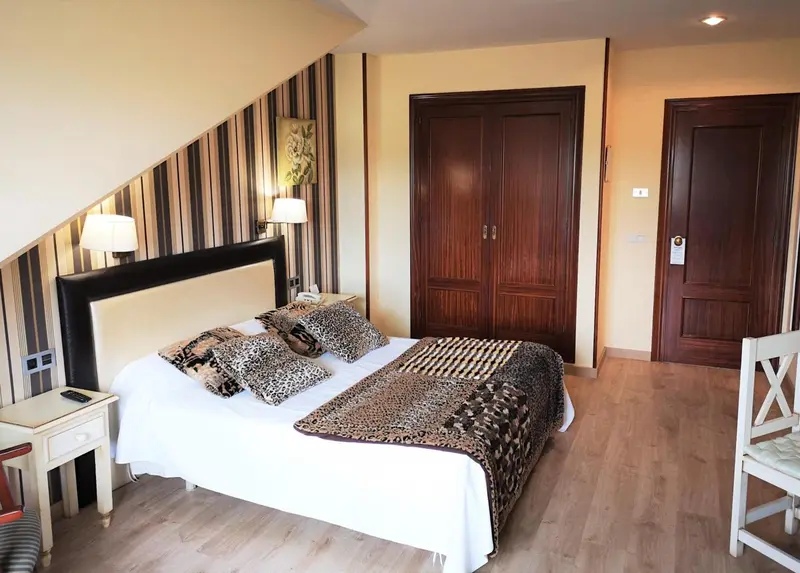 Une chambre lumineuse avec un grand lit recouvert d'une courtepointe décorative.