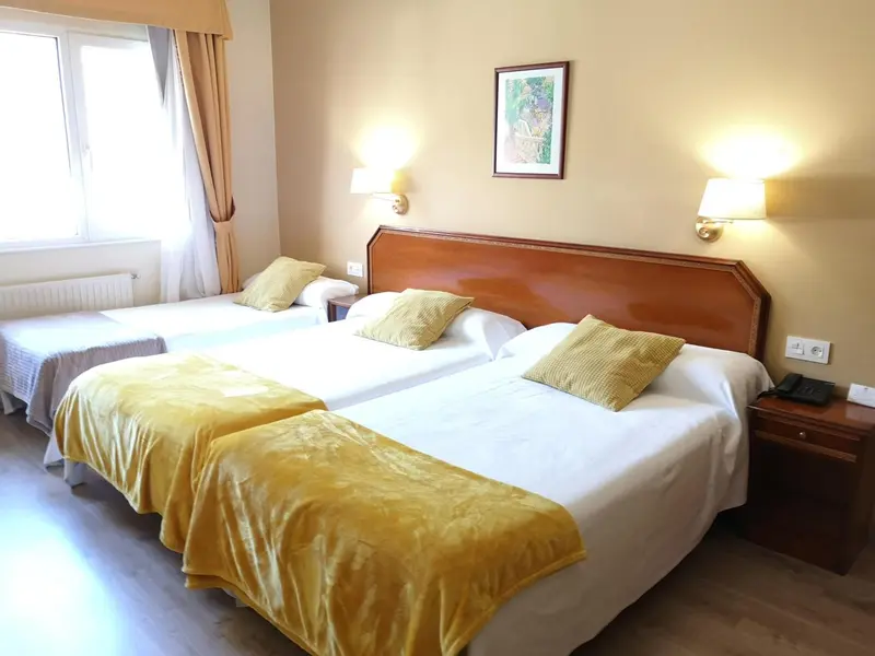 Une chambre d'hôtel avec deux lits simples et une décoration jaune.