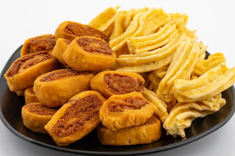 Assortiment de biscuits et de gressins sur une assiette noire.