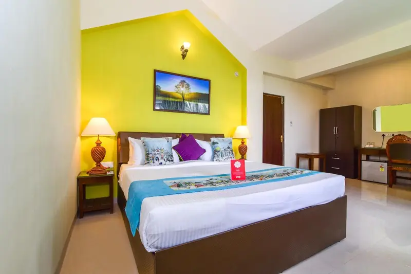 Une chambre lumineuse avec un grand lit recouvert d'une courtepointe colorée.