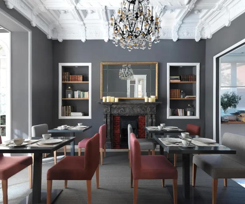 Une salle à manger élégante avec des tables dressées et une cheminée décorative.