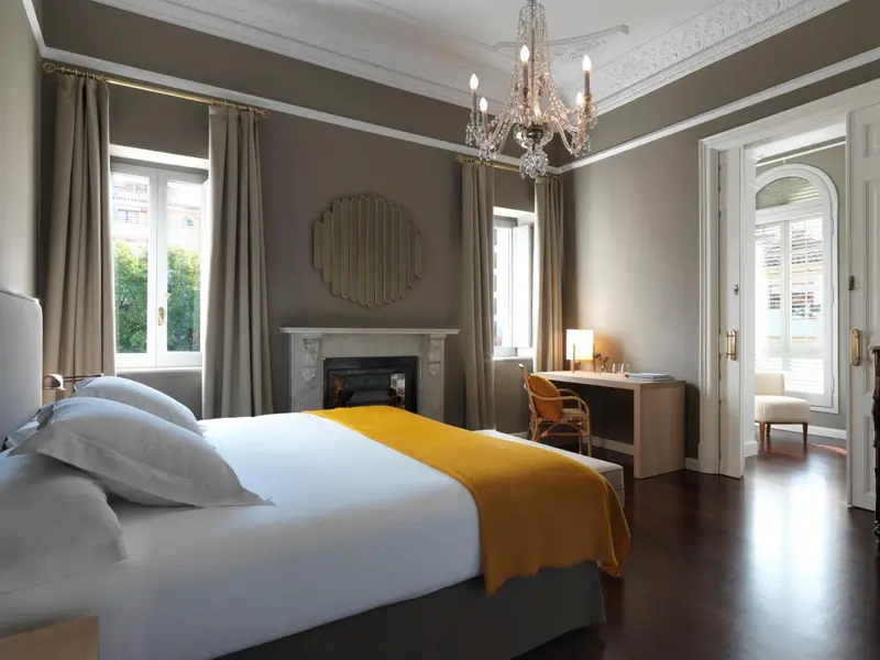 Une chambre lumineuse avec un lit recouvert d'une couverture jaune et un bureau en bois.