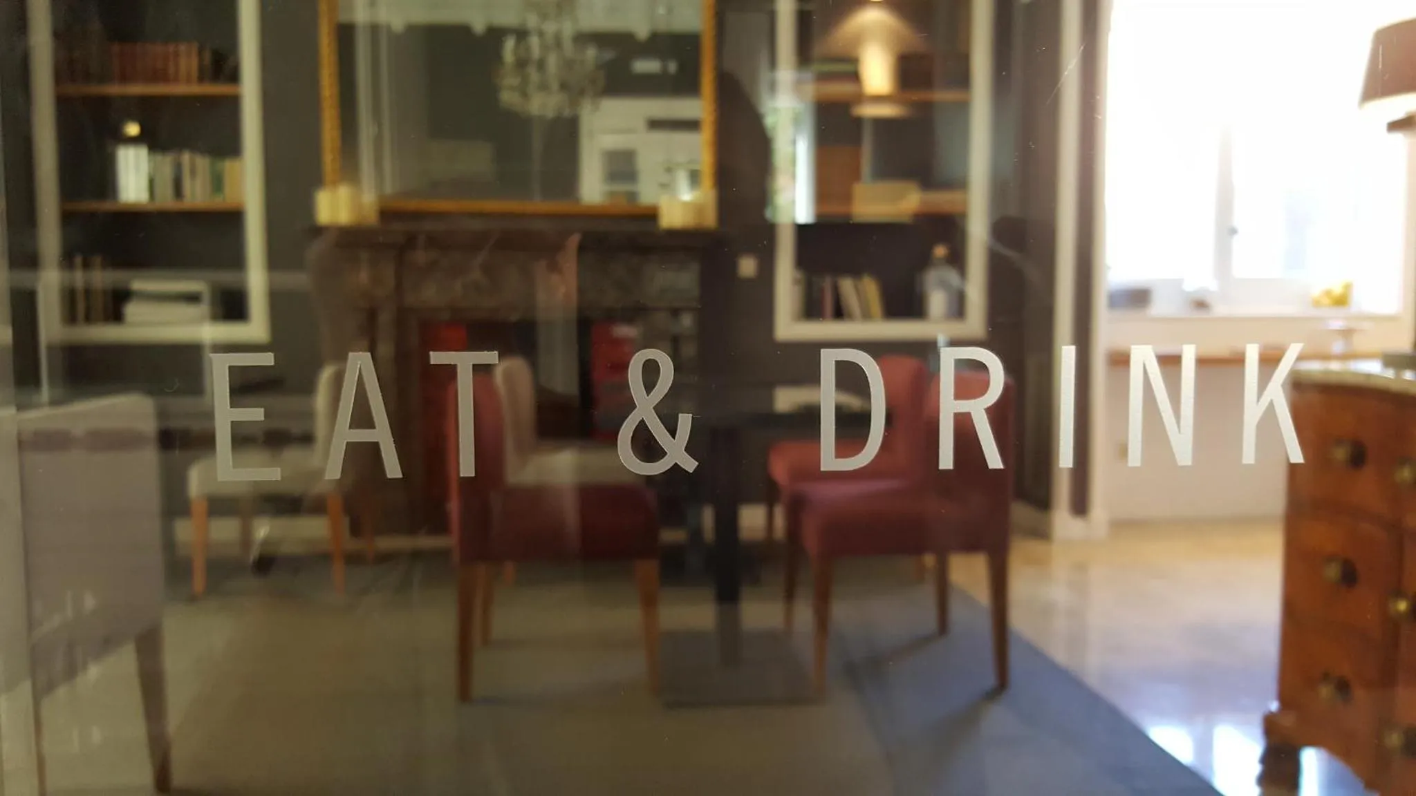 Une salle à manger avec des chaises rouges et des étagères en bois.