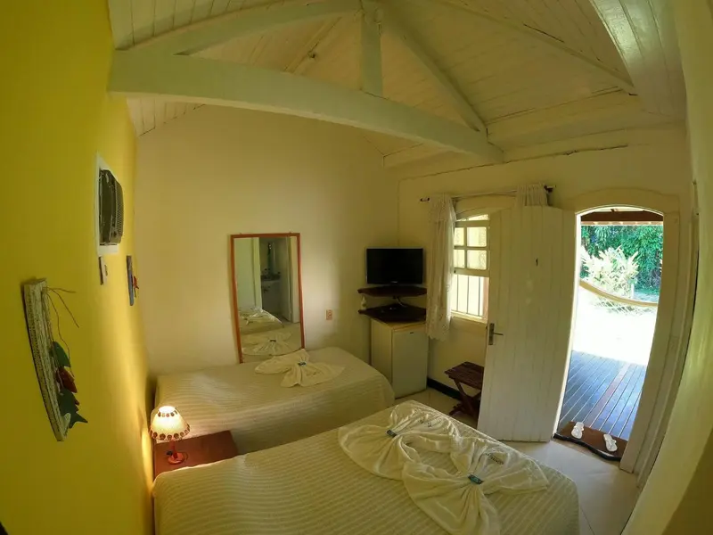 Une chambre lumineuse avec deux lits simples et une vue sur l'extérieur.