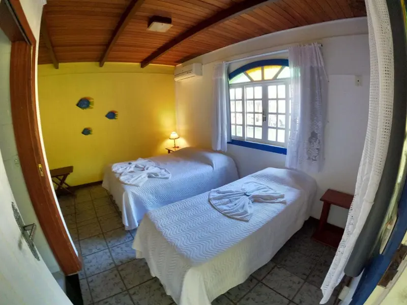 Une chambre lumineuse avec deux lits simples et une fenêtre.