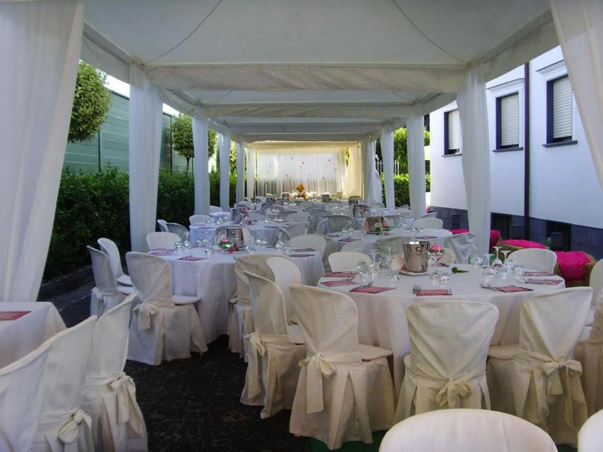 Tables dressées sous une tente blanche pour un repas en extérieur.