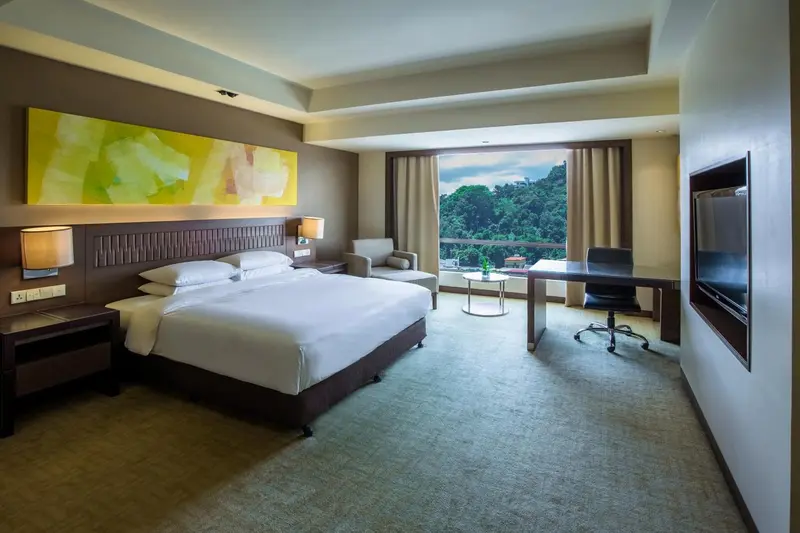 Une chambre lumineuse avec un grand lit et un espace de travail près d'une fenêtre.