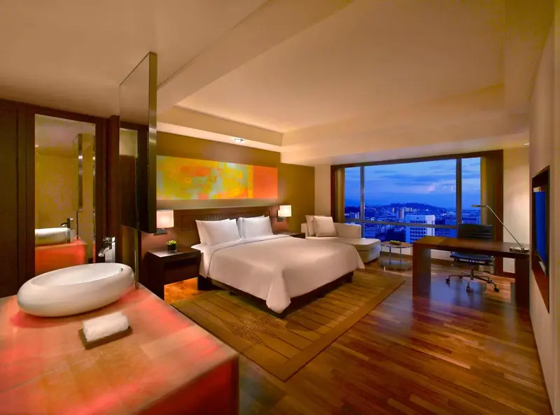Chambre lumineuse avec un grand lit et une baignoire moderne.