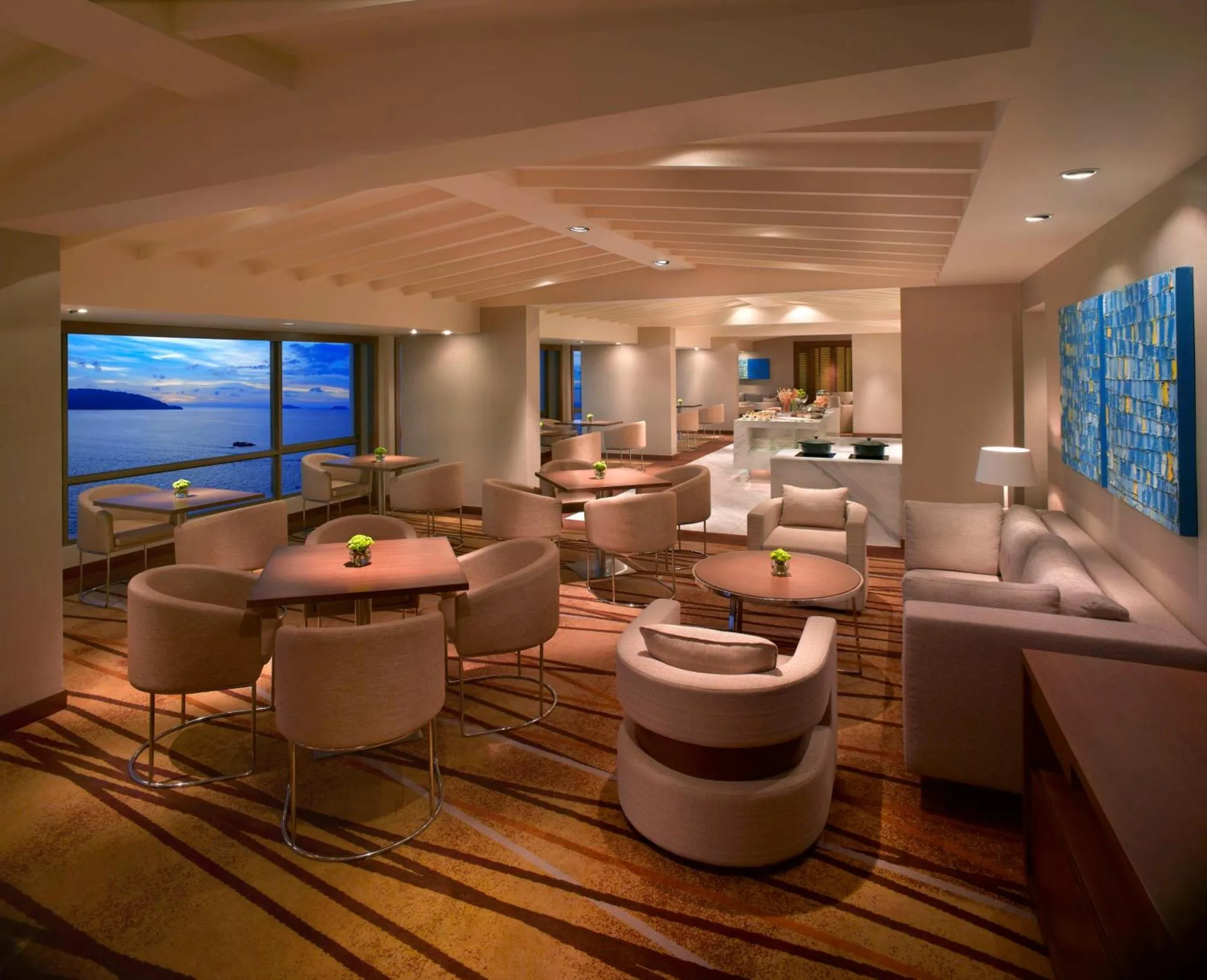 Espace de détente intérieur avec mobilier confortable et vue sur la mer.