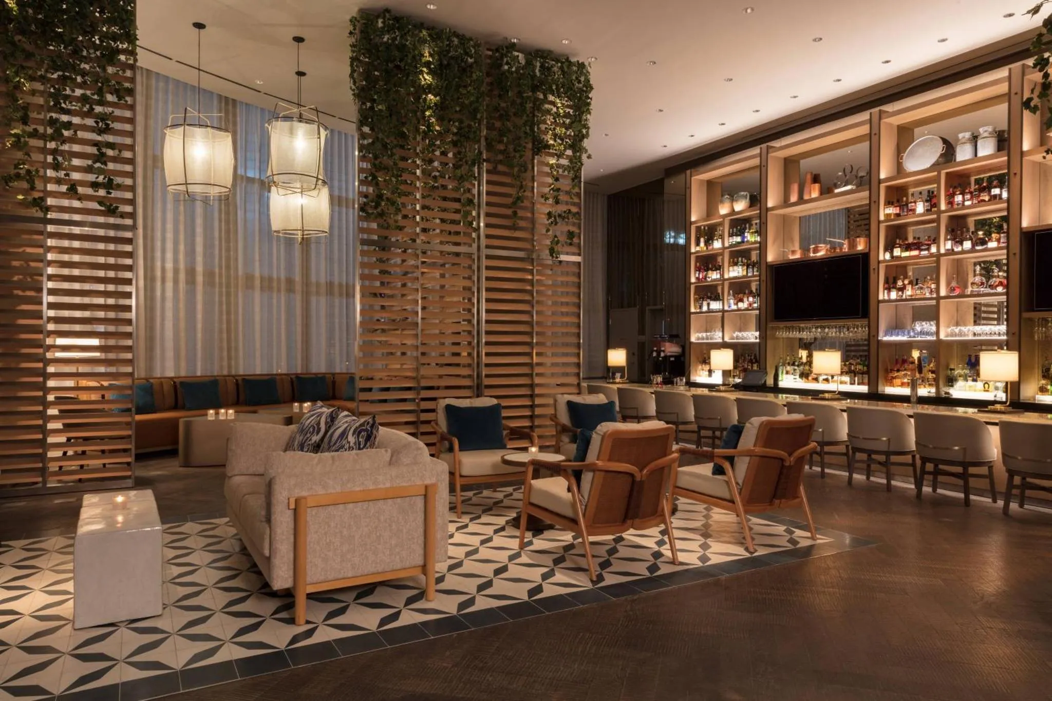 Un espace de détente intérieur avec canapés, fauteuils et un comptoir de bar.