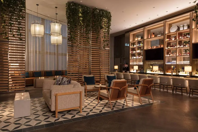 Un espace de détente intérieur avec canapés, fauteuils et un comptoir de bar.